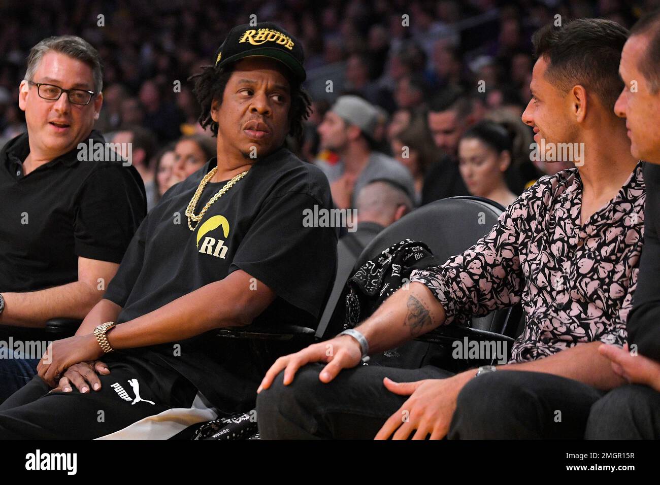 Rapper Jay-Z, left, looks over at soccer player Chicharito during