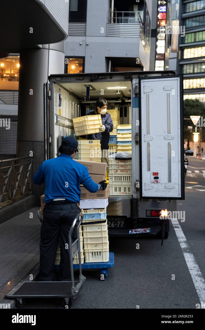 Tokyo, Japan. 26th Jan, 2023. Logistics delivery workers prepare a shipment to to deliver food products to a Japanese restaurant in the busy commercial district of Shibuya. Food and beverage industry, hospitality. The Japanese economy remains stagnant as workers' wages have not increased in 30 years at the same time as the Bank of Japan's longtime negative interest rates have caused the Yen to struggle against the US Dollar due to the United States' Fed Funds rate hikes to combat inflation. This has promoted severe international trade concerns as Japan is a major trading partner with Ameri Stock Photo