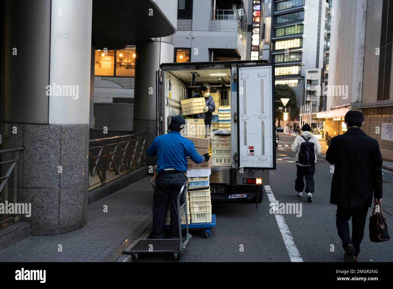 Tokyo, Japan. 26th Jan, 2023. Logistics delivery workers prepare a shipment to to deliver food products to a Japanese restaurant in the busy commercial district of Shibuya. Food and beverage industry, hospitality. The Japanese economy remains stagnant as workers' wages have not increased in 30 years at the same time as the Bank of Japan's longtime negative interest rates have caused the Yen to struggle against the US Dollar due to the United States' Fed Funds rate hikes to combat inflation. This has promoted severe international trade concerns as Japan is a major trading partner with Ameri Stock Photo