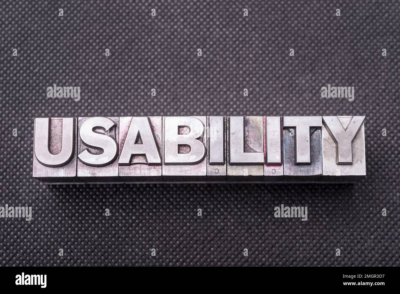 usability word made from metallic letterpress blocks on black perforated surface Stock Photo