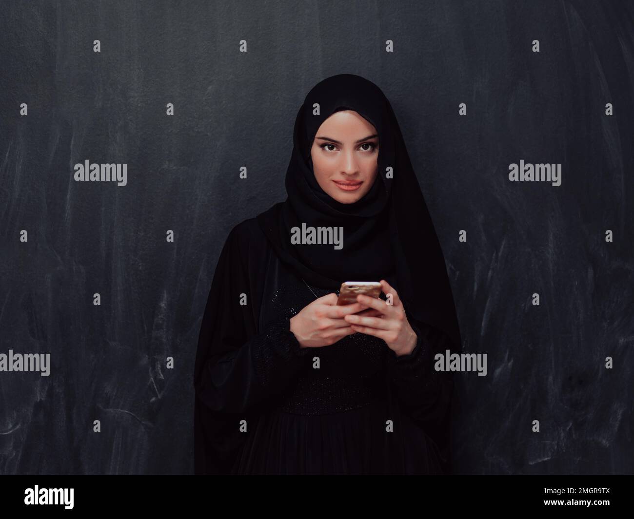 Young modern muslim business woman using smartphone wearing hijab ...