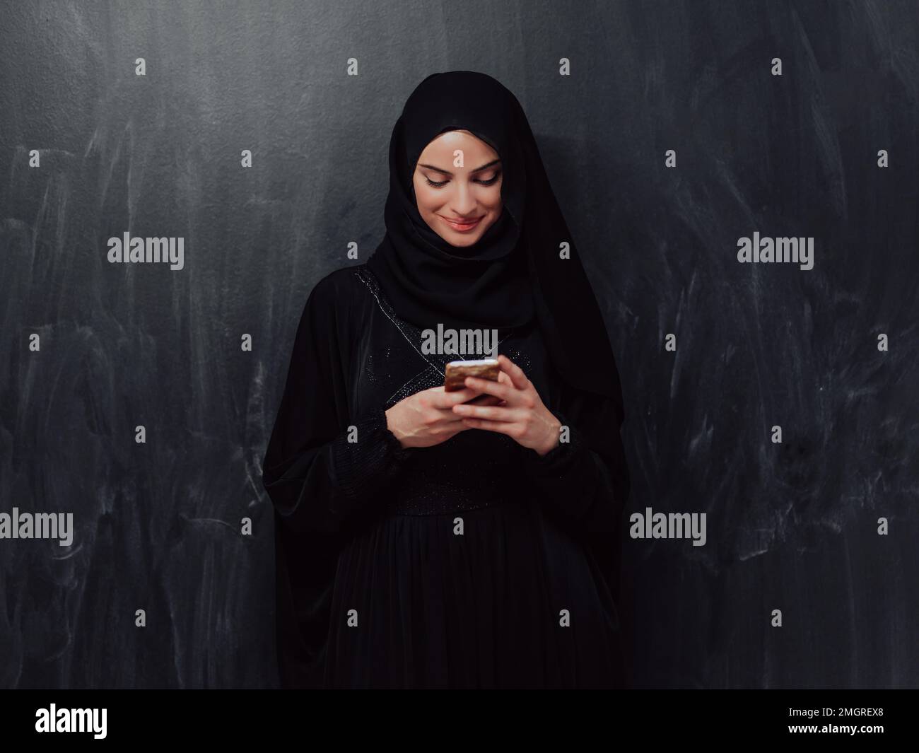 Young modern muslim business woman using smartphone wearing hijab ...