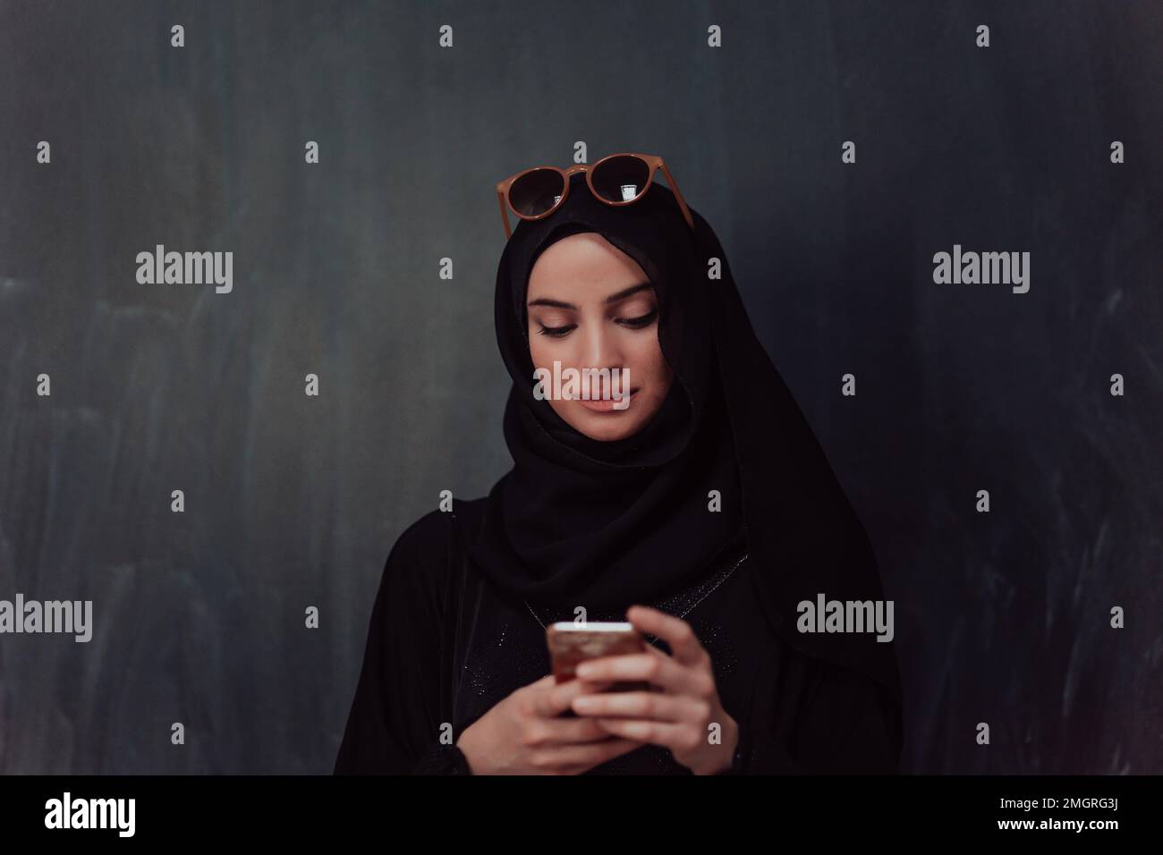 Young modern muslim business woman using smartphone wearing hijab ...