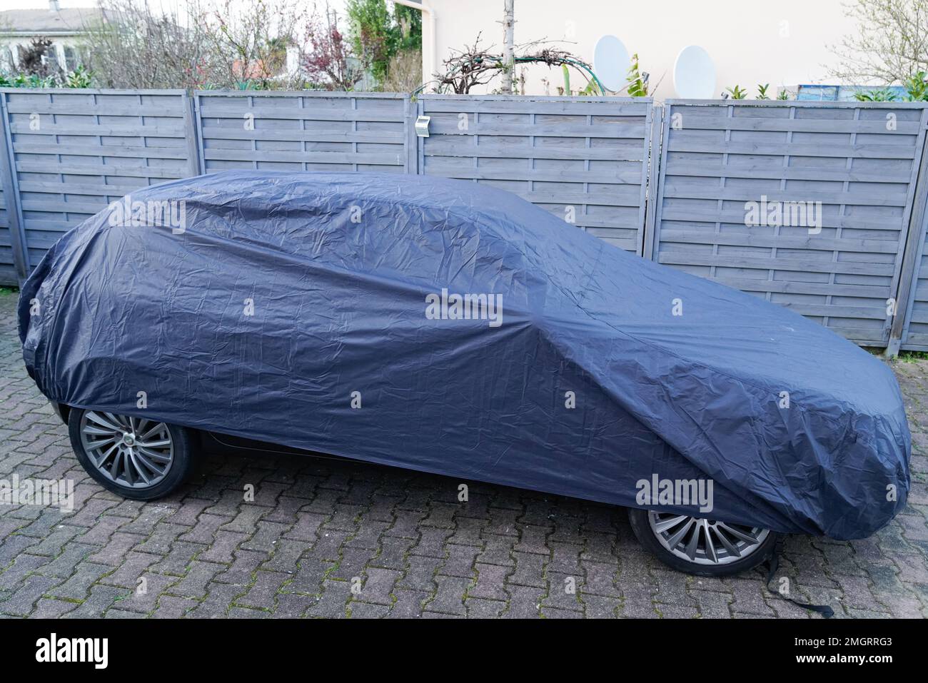 car parked under blue colored cover outside in winter Stock Photo Alamy