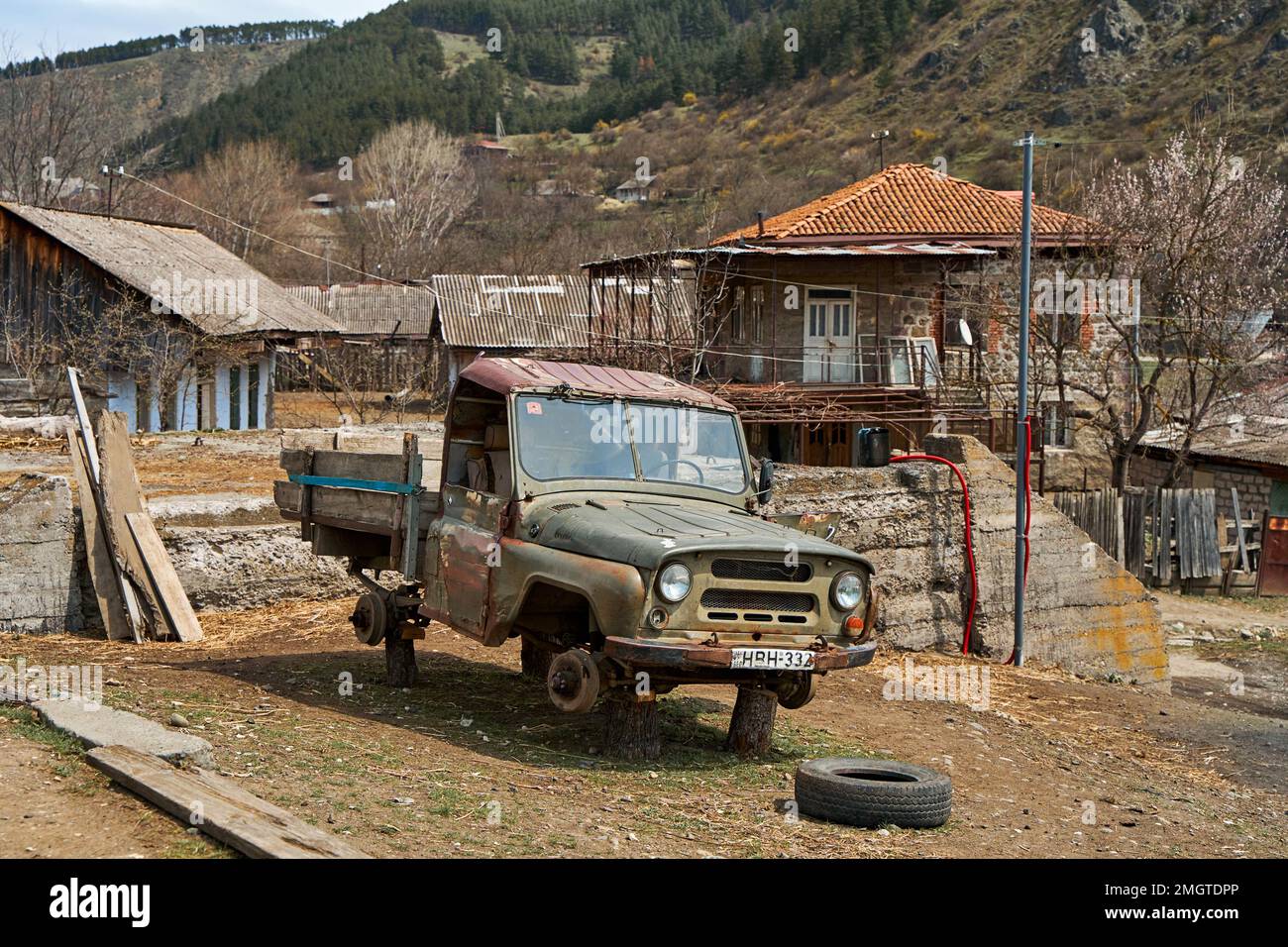 An old Soviet VAZ car with the wheels off is abandoned in the village ...