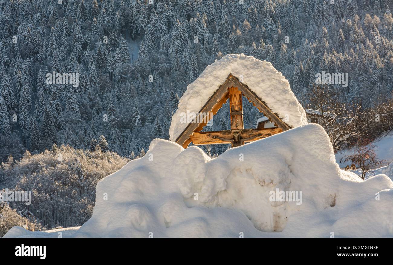 Catholic Wayside Shrine In Winter snow covered - Adamello Brenta Natural Park, Trentino Alto Adige, northern Italy, Europe Stock Photo
