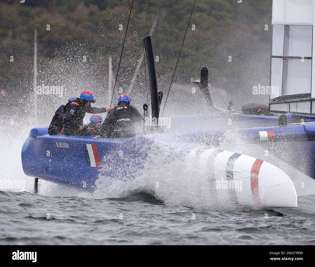 The French team slow their boat after crossing the finish line in the ...