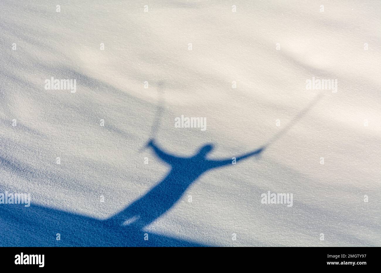 shadow of walking person with pole on snow in winter Stock Photo