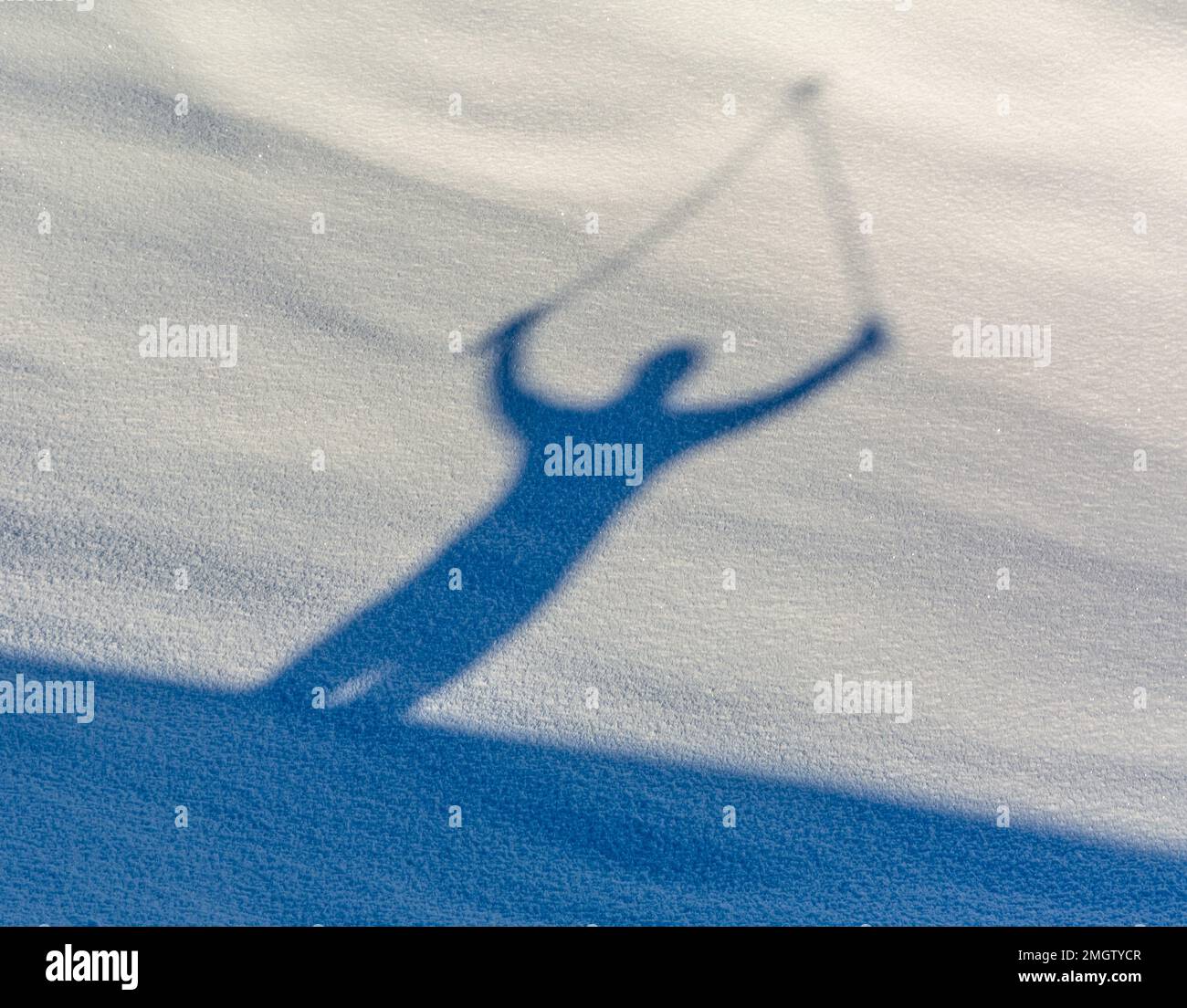 shadow of walking person with pole on snow in winter Stock Photo
