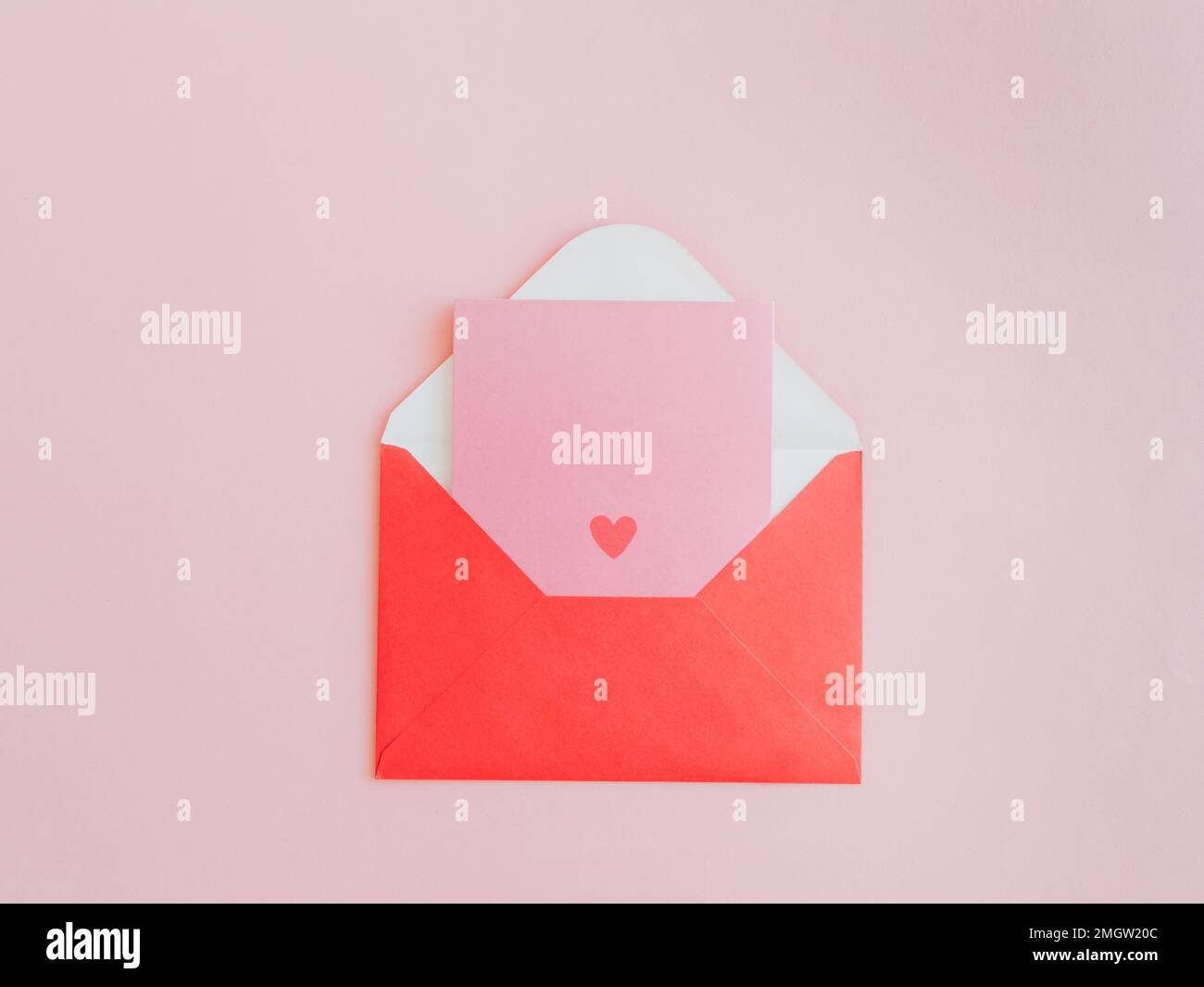 Red paper envelope with blank pink card with red valentines heart on ...