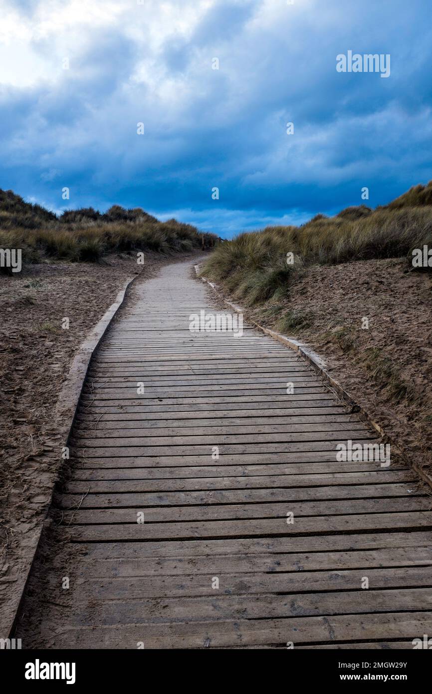A wooden walkway leads to the beach and sea at Formby. Stock Photo