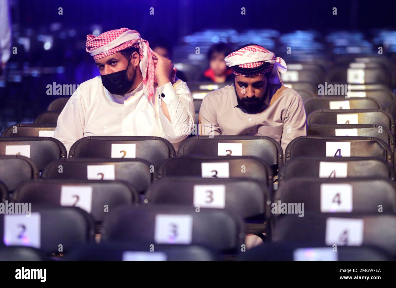A Saudi wrestling fan wears a protective mask as he waits for wrestling