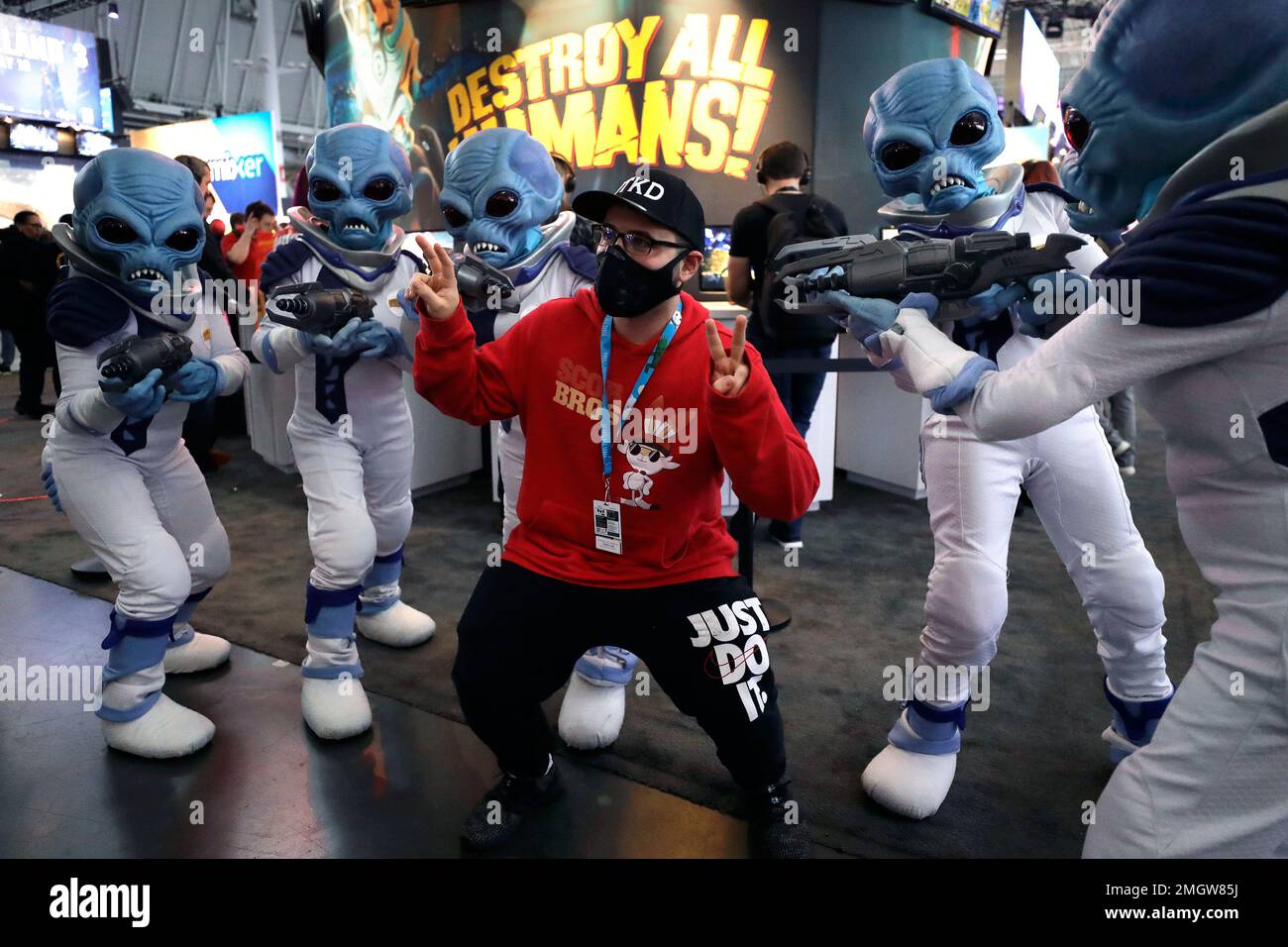 Eric Vita, of Morris Plains, N.J., center, wears a protective mask while  posing for a photograph with people dressed as 