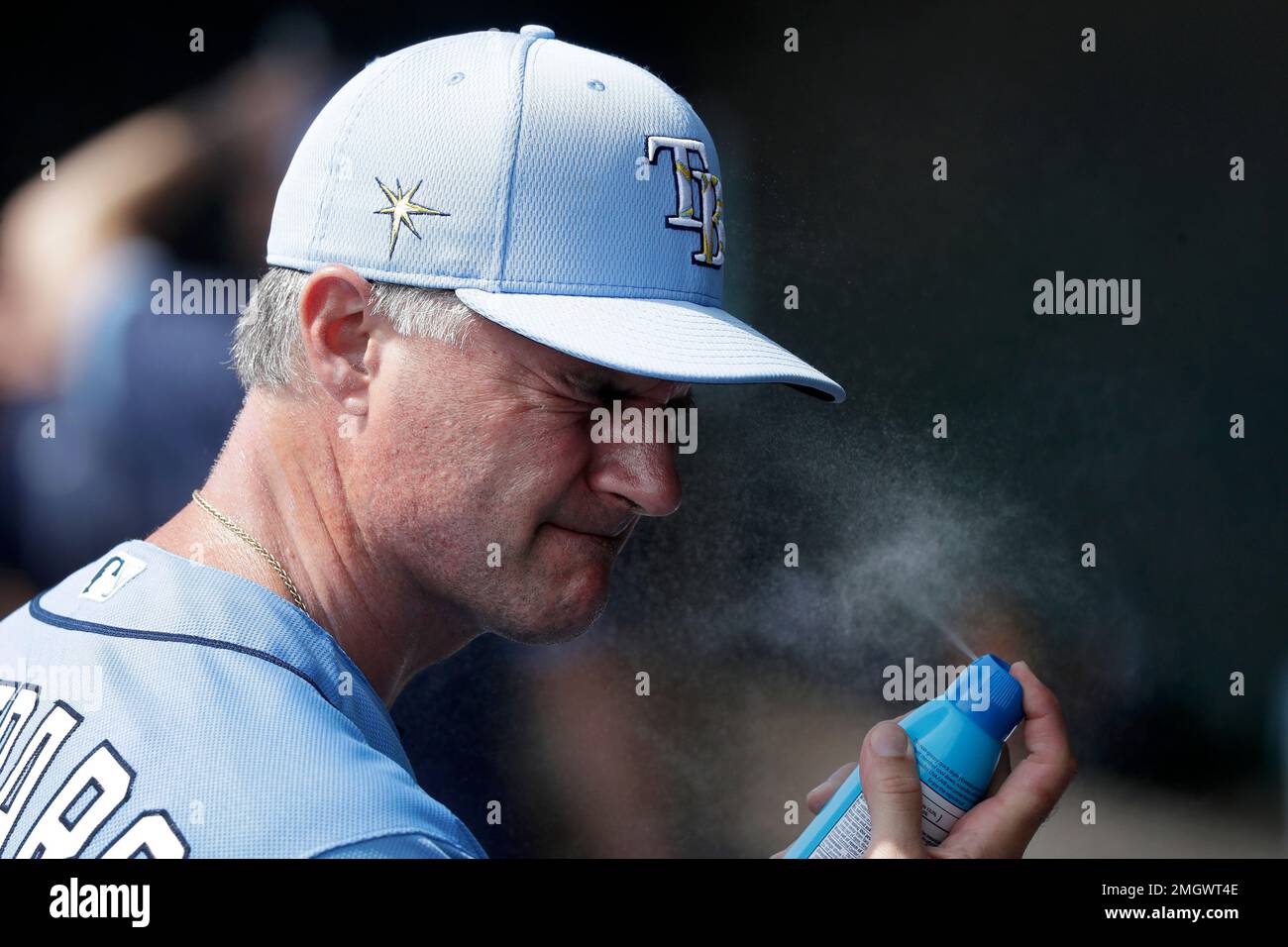 Tampa Bay Rays bench coach Matt Quatraro applies sunscreen before a