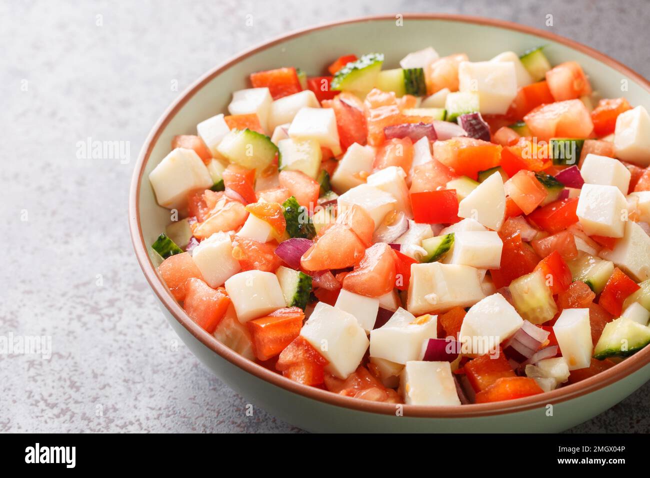 Bahamian conch salad is a vibrant and crunchy salad made using raw pound conch meat and vegetables closeup on the plate on the table. Horizontal Stock Photo