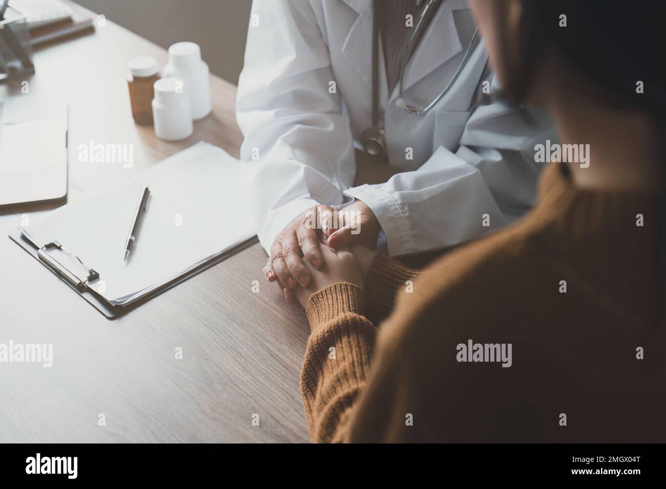 Doctor talking with asian woman. Female primary care physician having conversation with older woman. Elderly Healthcare Stock Photo