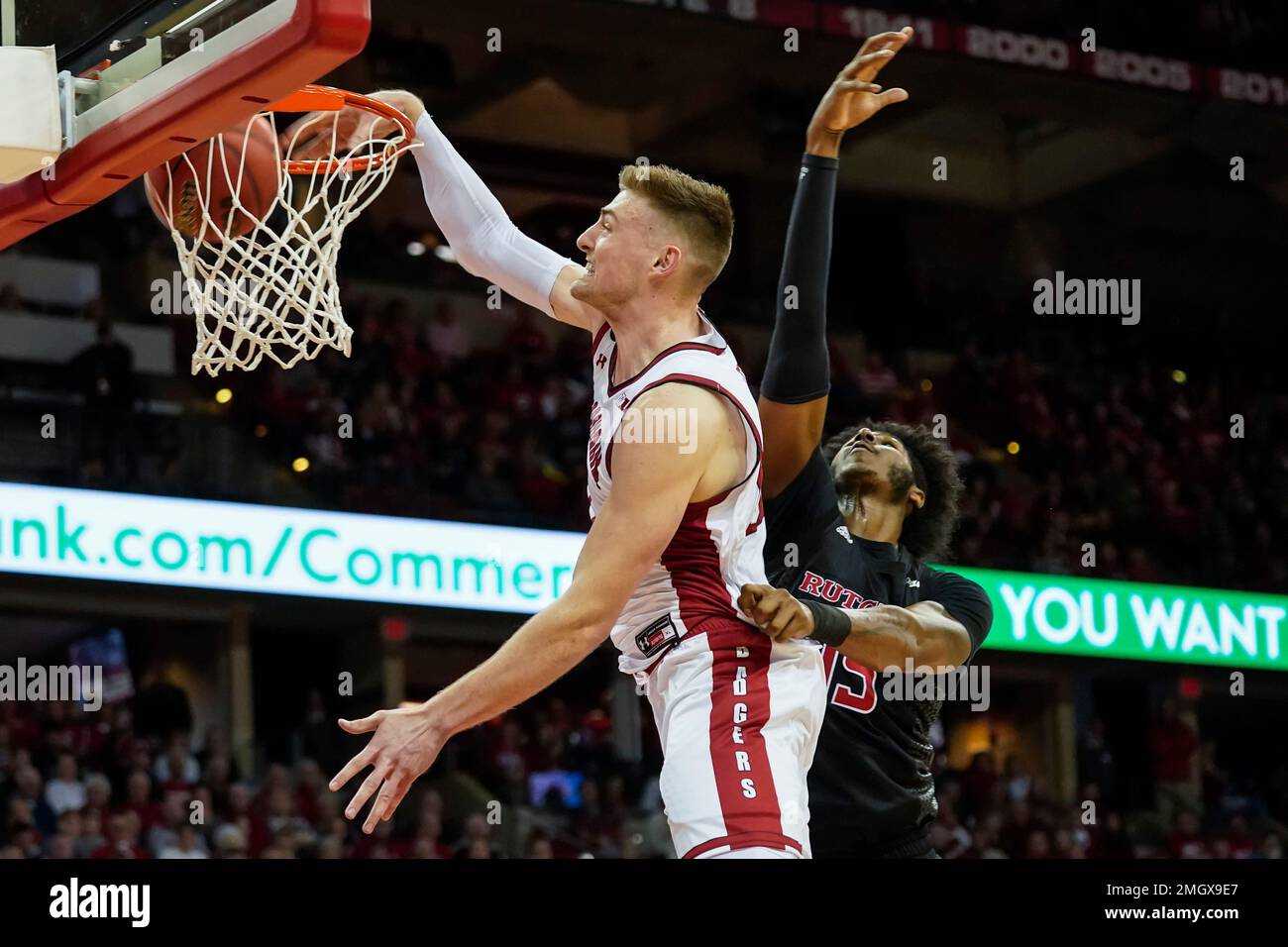 Wisconsin's Micah Potter, left, dunks past Rutgers' Myles Johnson (15