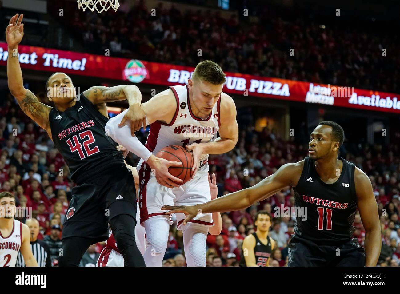 Wisconsin's Micah Potter, center, grabs a defensive rebound against