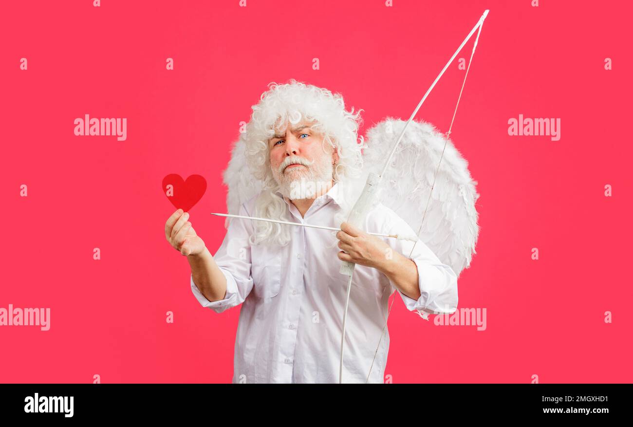 Valentines Day. Angel in white wings with bow and arrow hold red paper heart. Valentine cupid. Love. Stock Photo