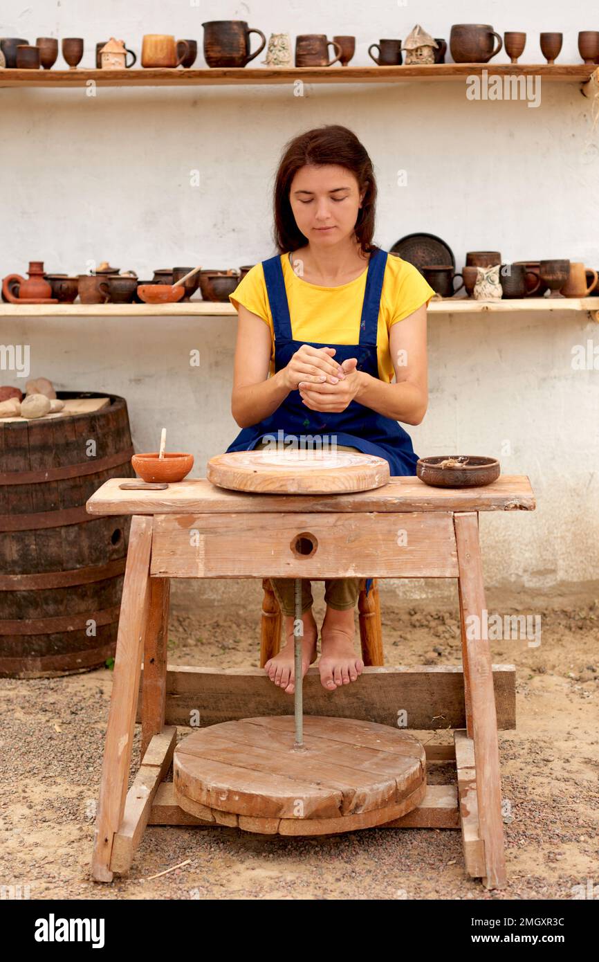 professional potter with clay lump in hands. woman work on pottery