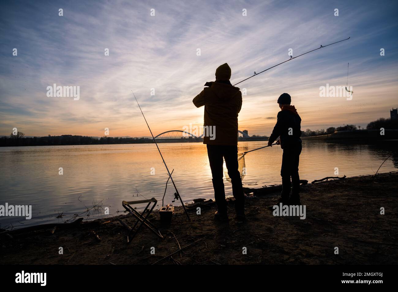 https://c8.alamy.com/comp/2MGXTGJ/teenage-boy-is-fishing-on-river-bank-boy-is-fishing-in-sunset-2MGXTGJ.jpg