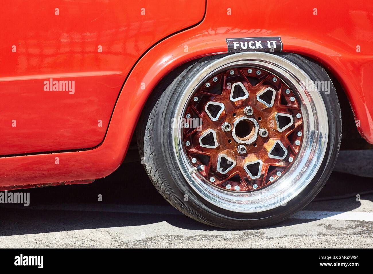shiny wheel close-up on a tuned red car with a low landing. Stock Photo