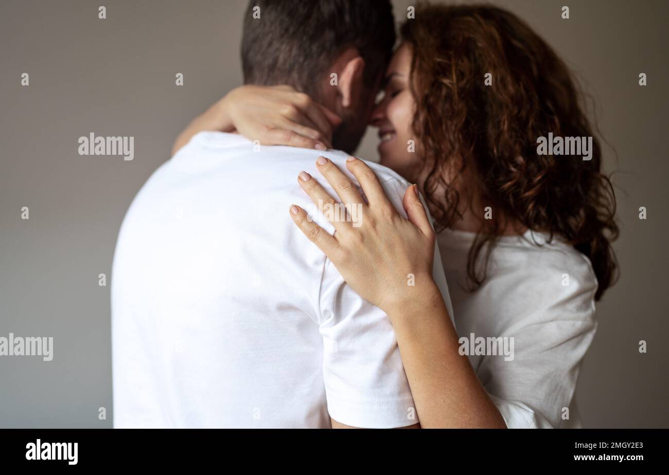 Happy young adult heterosexual couple in tender embrace, people in love, gently relationship. Stock Photo