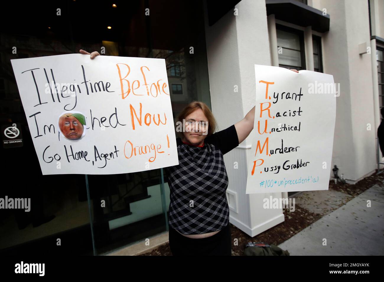 EDS NOTE: OBSCENITY - A protester holds signs outside of a campaign ...