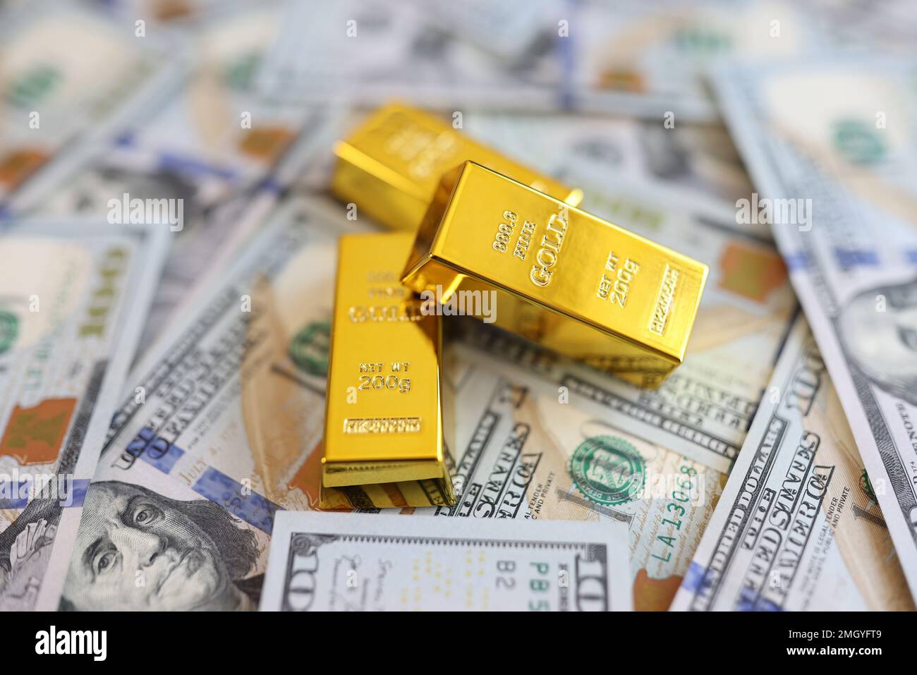 Gold bars on background of US dollar banknotes close-up. Stock Photo