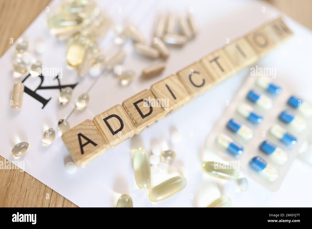 Word addiction, collected from wooden cubes with letters on doctor's prescription with many pills. Stock Photo