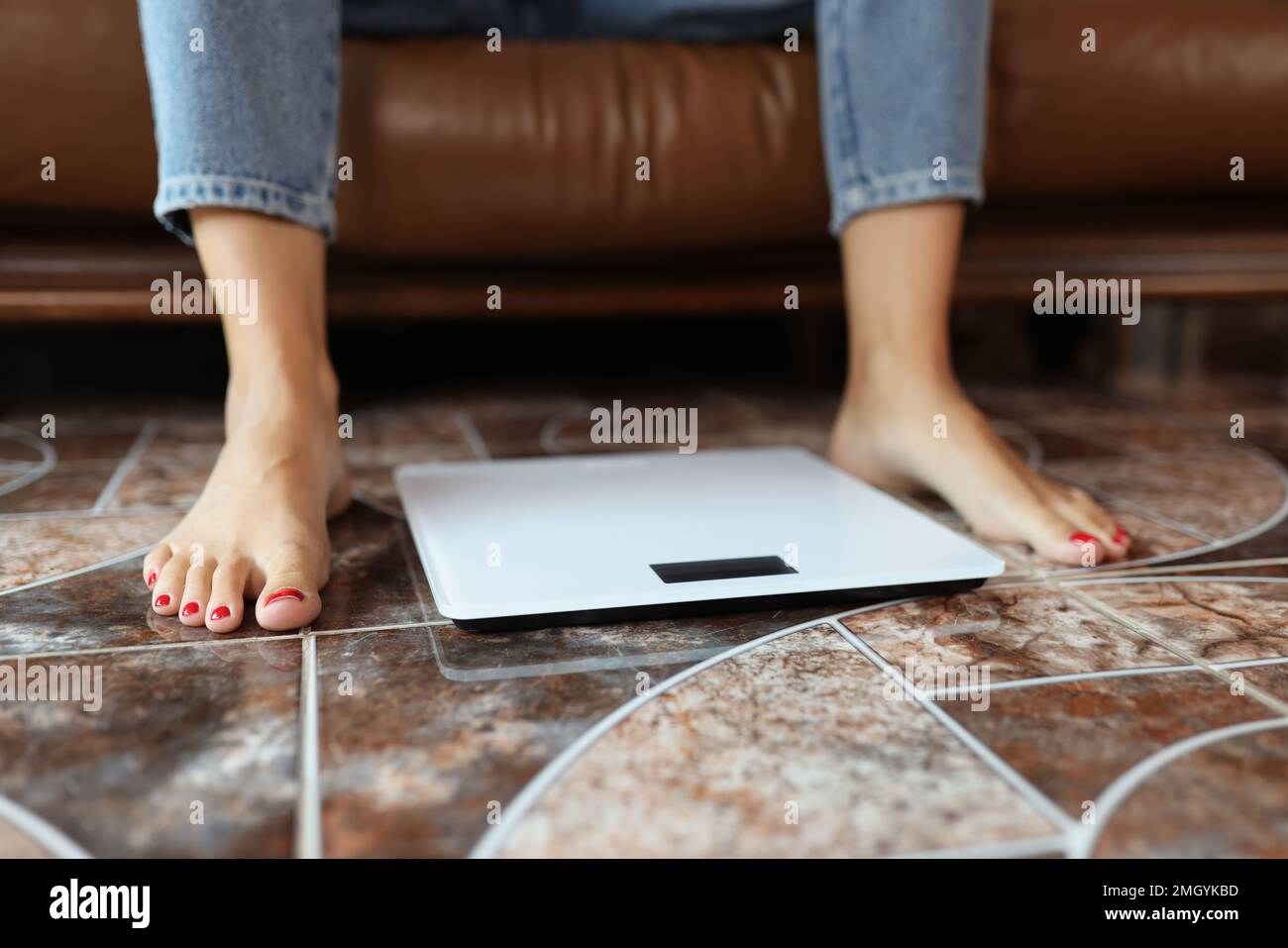 Women's legs and scales on the floor close-up. Stock Photo