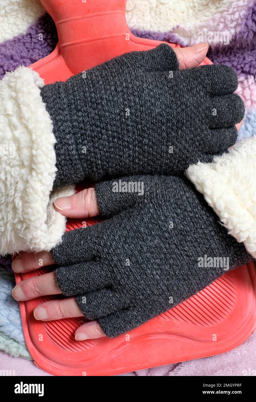 woman wearing pyjamas cuddling a hot water bottle for comfort & to keep  warm Stock Photo - Alamy