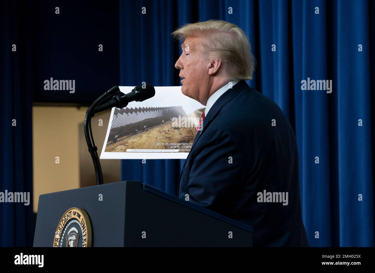 President Donald Trump displays photos of the border wall under ...