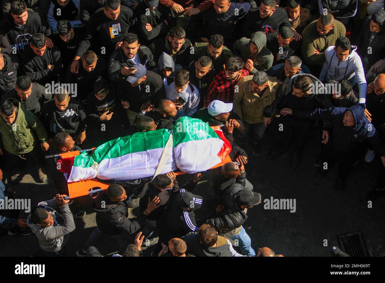 Jenin, Middle East. 26th Jan, 2023. (EDITOR'S NOTE: Image depicts death)Mourners carry the body of the 60-year-old Palestinian woman, Majida Obaid, one of the ten Palestinians killed by the Israeli army during a raid in the city of Jenin in the occupied West Bank. Large forces of the Israeli army stormed the city of Jenin and killed ten Palestinians, including a woman, and wounding more than twenty others with live bullets during the clashes between them and the forces that confronted them. The army said that the raid was on an apartment of the cell in the Jenin refugee camp, which began after Stock Photo