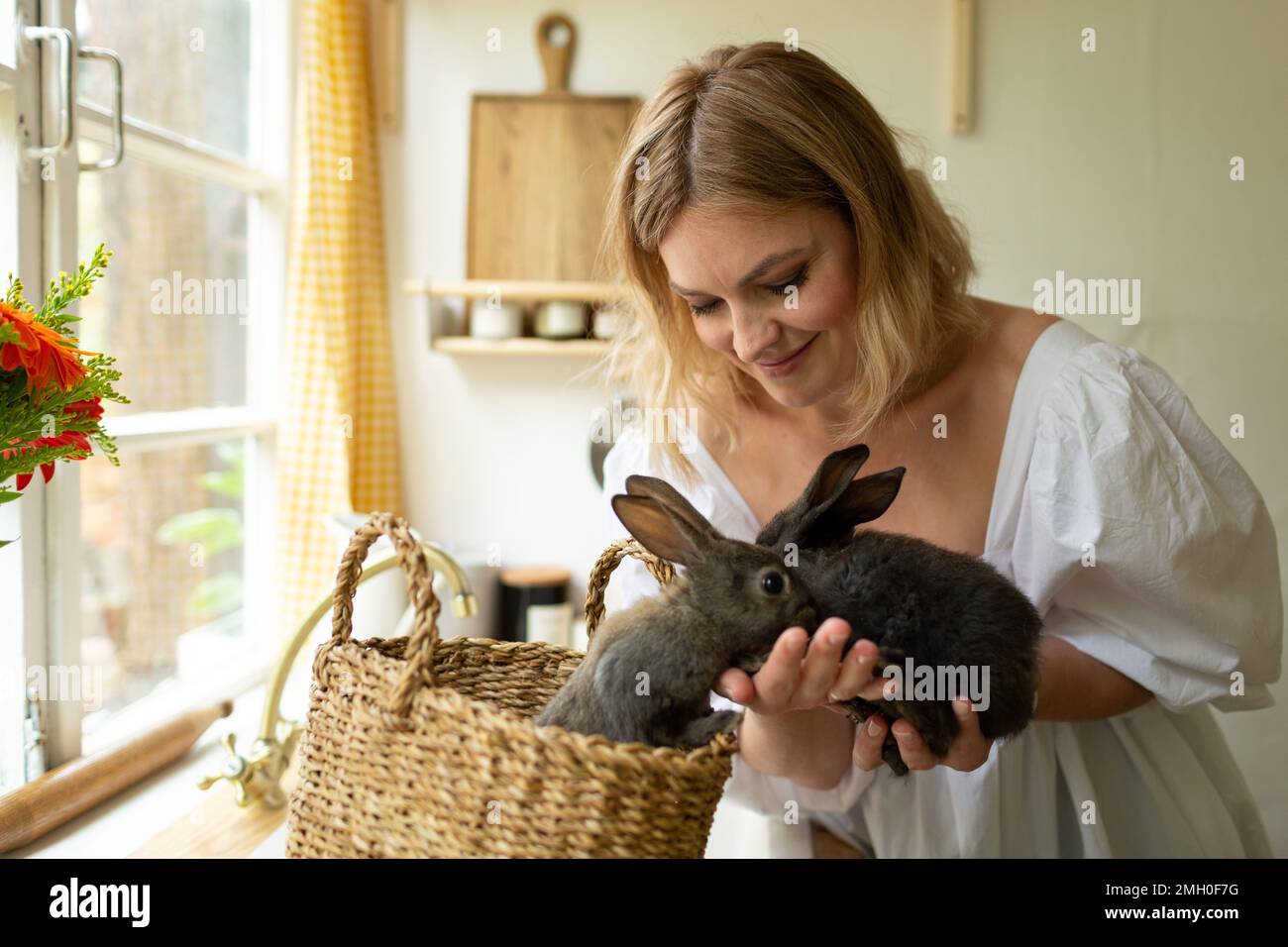A woman holds rabbits, smiles, Easter concept Stock Photo - Alamy