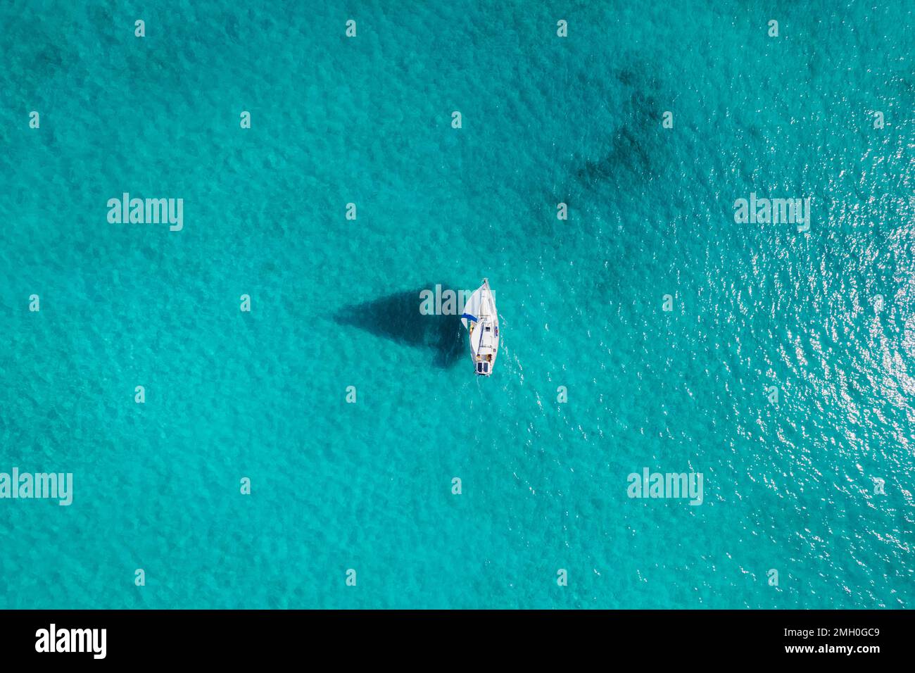 Aerial of Sailboat Sailing Through Turquoise Bahamas Waters Stock Photo