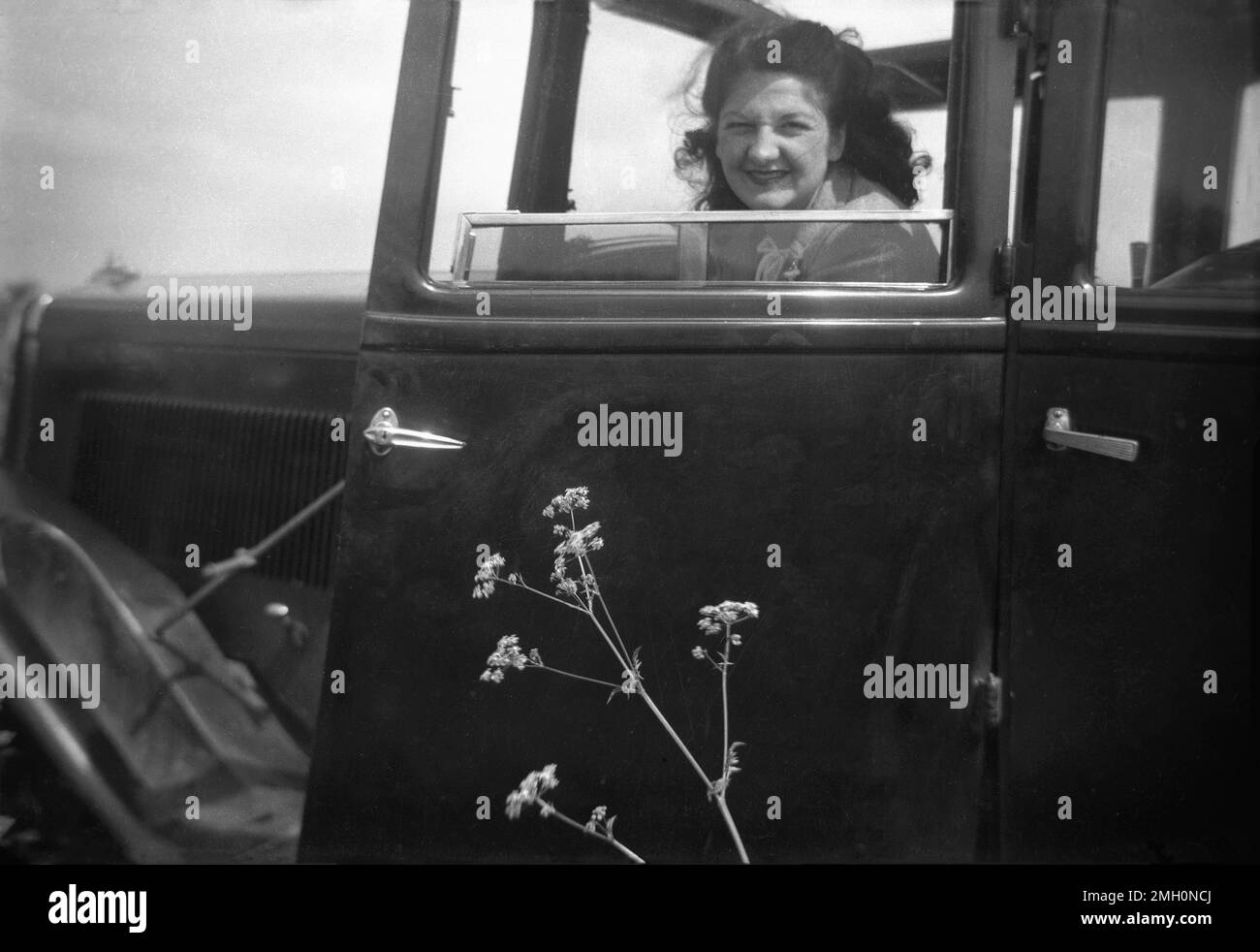 circa late 1940s, historical, a lady sitting in passenger seat of a car of the era looking out of the window, which is wound down, England, UK. In this era, car ownership was low in Britain and going out for a day out to the countryside was a big occasion. Stock Photo