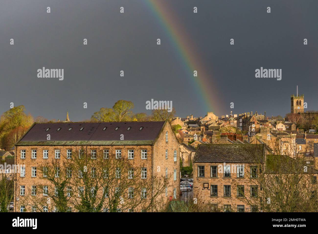 A vivid rainbow drops on the centre of Barnard Castle during the briefest burst of very strong patchy sunshine. Stock Photo