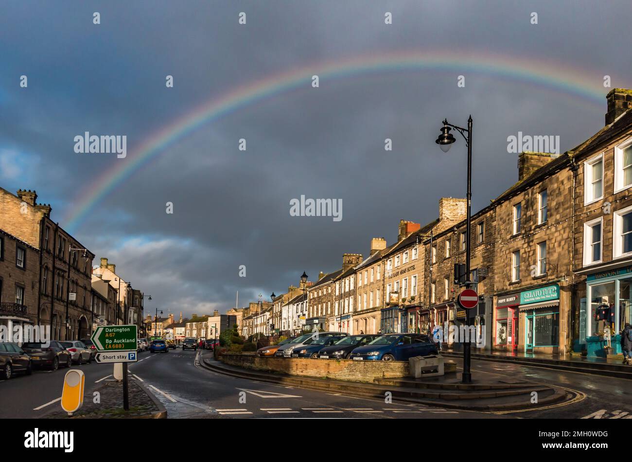 A rainbow forms over Barnard Castle Market Place during a brief interval of strong sunshine. Stock Photo