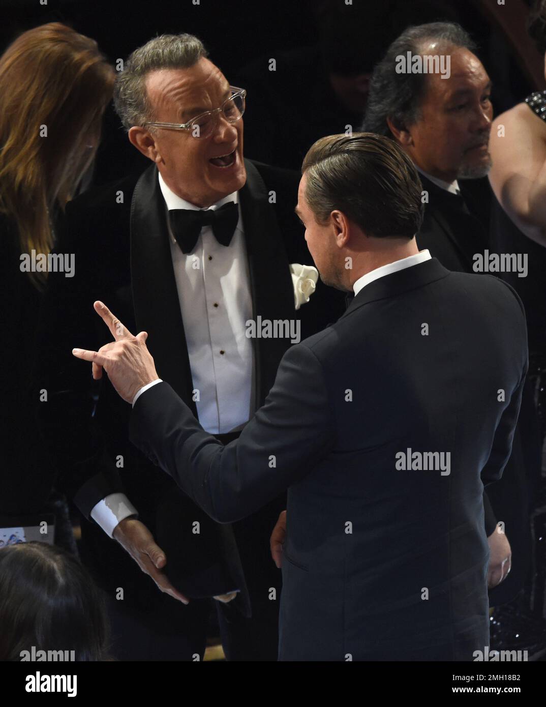 Tom Hanks, left, speaks with Leonardo DiCaprio in the audience at the ...