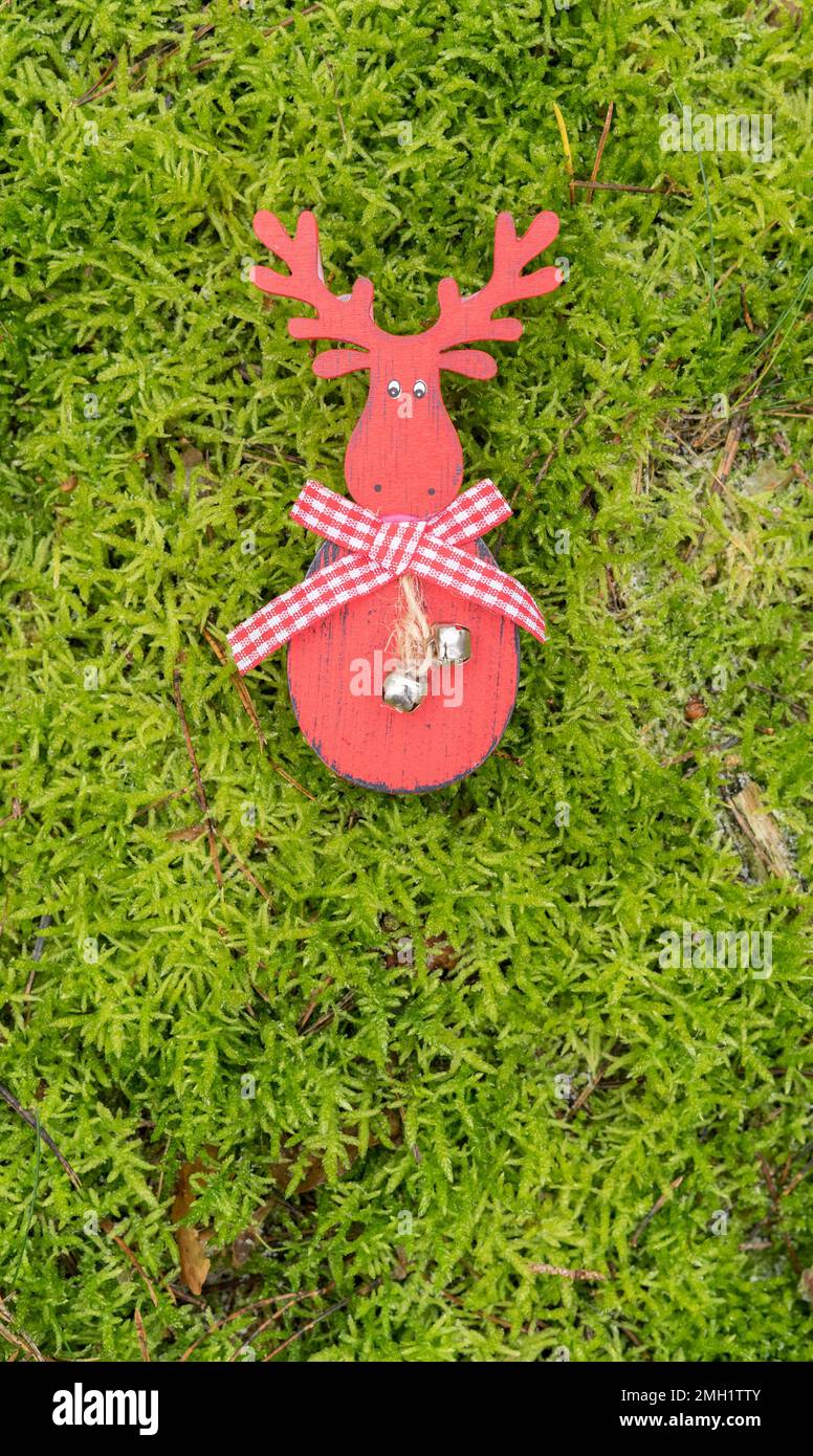 red reindeer figure on green moss surface Stock Photo