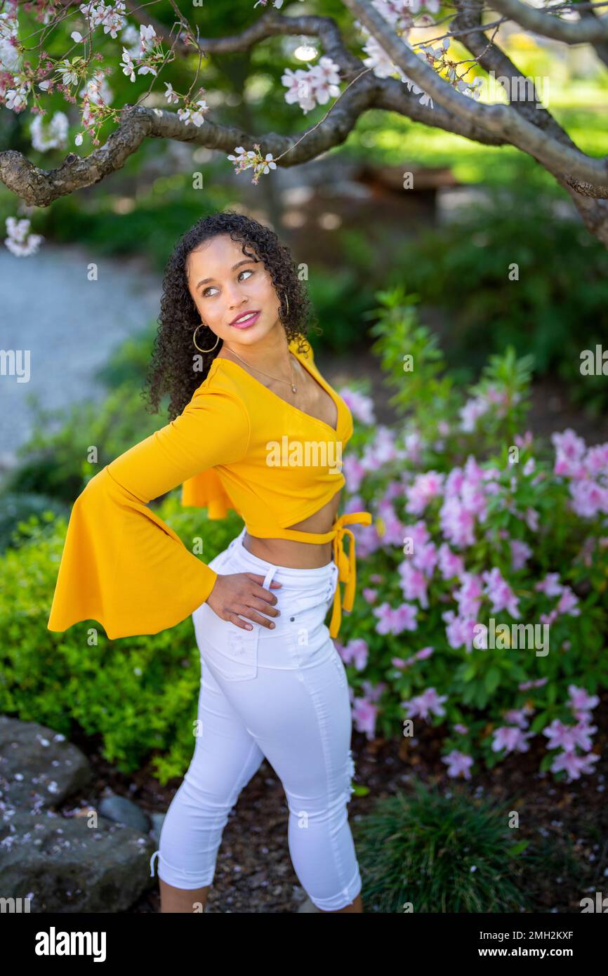 Down Angle Portrait of Happy Young African American Woman in a Blossoming Japanese Style Garden at Springtime - Spring Stock Photo