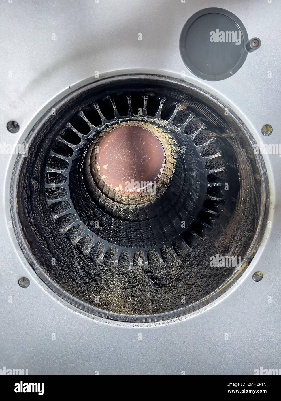 Opened combustion chamber of an oil heating system. The combustion chamber has been cleaned of soot and residues. Traces of the brush used can be seen Stock Photo