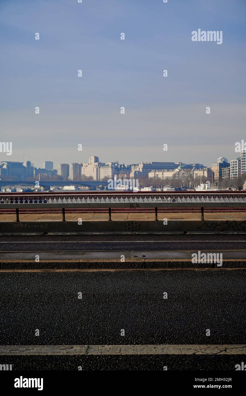 View of london skyline over blackfriars bridge with no traffic but small group of people walking past on sunny Stock Photo