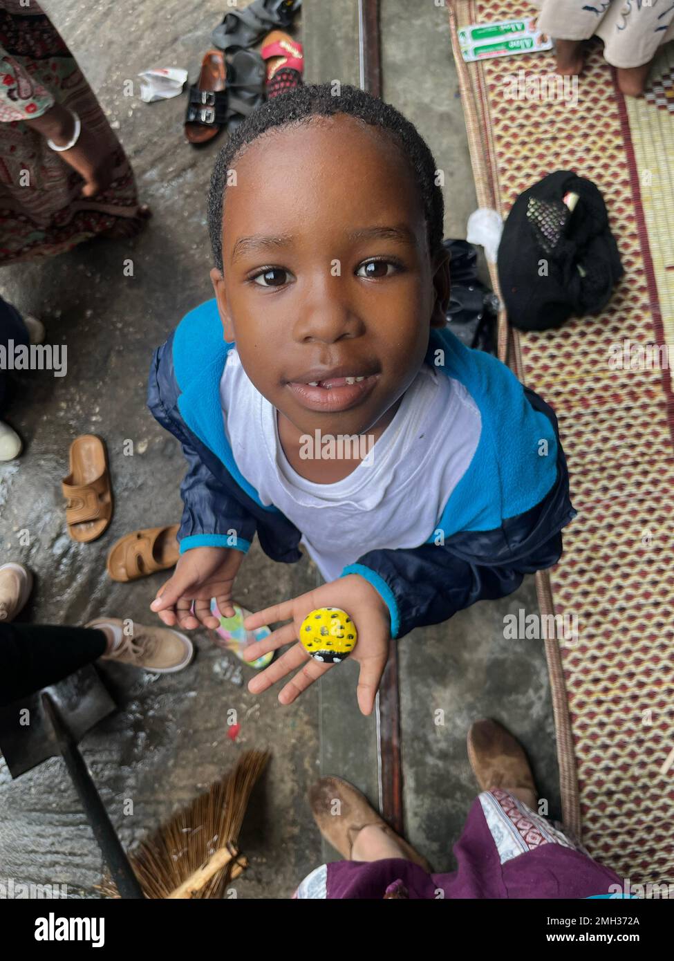 close up of an African Kid holding a rock crafts, rock art and crafts. review of daily life of local people in Zanzibar, Tanzania. Stock Photo