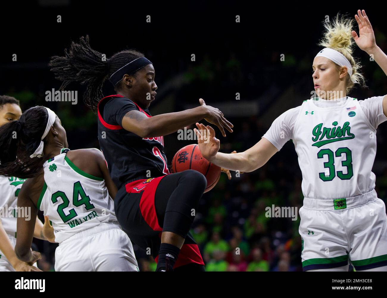 Louisville's Jazmine Jones, center, grabs a rebound between Notre Dame