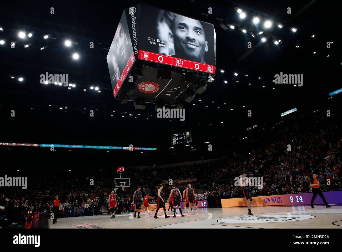 Olimpia Milan and Bayern Munich players stand under a picture of Kobe  Bryant projected on a giant screen prior to the start of the Euro League  basketball match between Olimpia Milan and