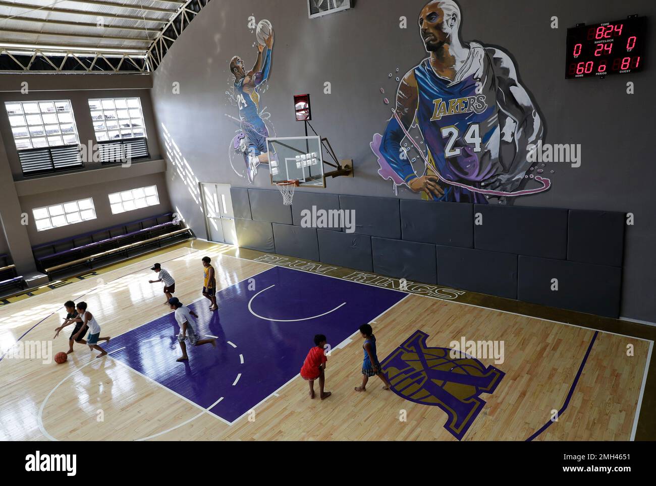 Boys play beside images of former NBA basketball player Kobe Bryant at