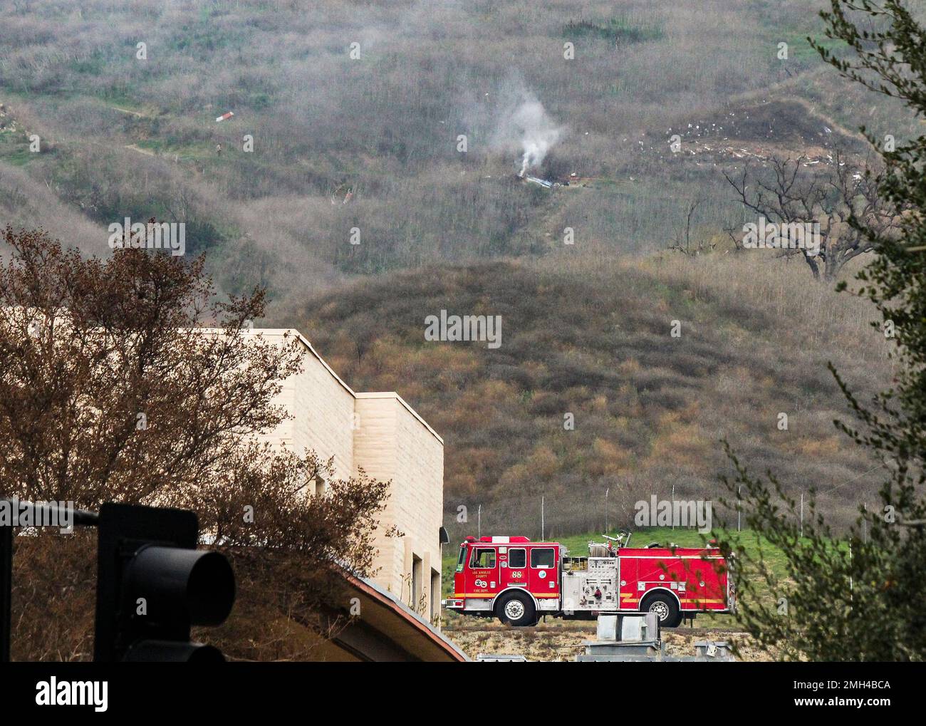 A sheriff officer, left, stands by the scene of a helicopter crash