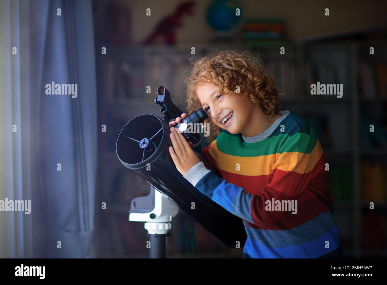 Little boy looking at stars through telescope. Child watching night sky and moon. Astronomy and science for young explorer kid. Stock Photo